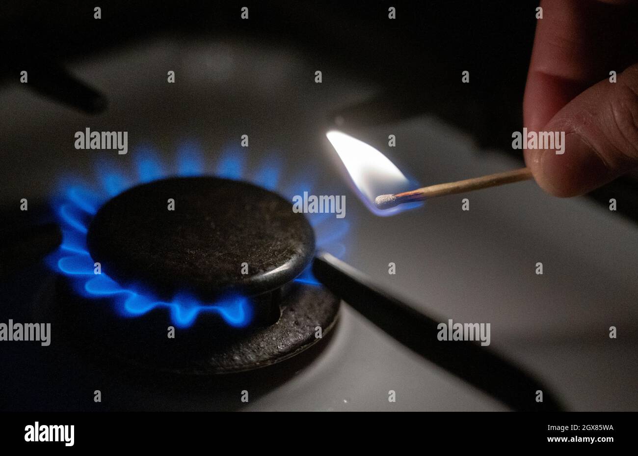 Stoccarda, Germania. 05 ottobre 2021. Una fiamma di gas è accesa su una stufa da cucina con un fiammifero. Il gas e l'elettricità sono più costosi in Europa di quanto non lo siano stati da molto tempo. Credit: Marijan Murat/dpa/Alamy Live News Foto Stock