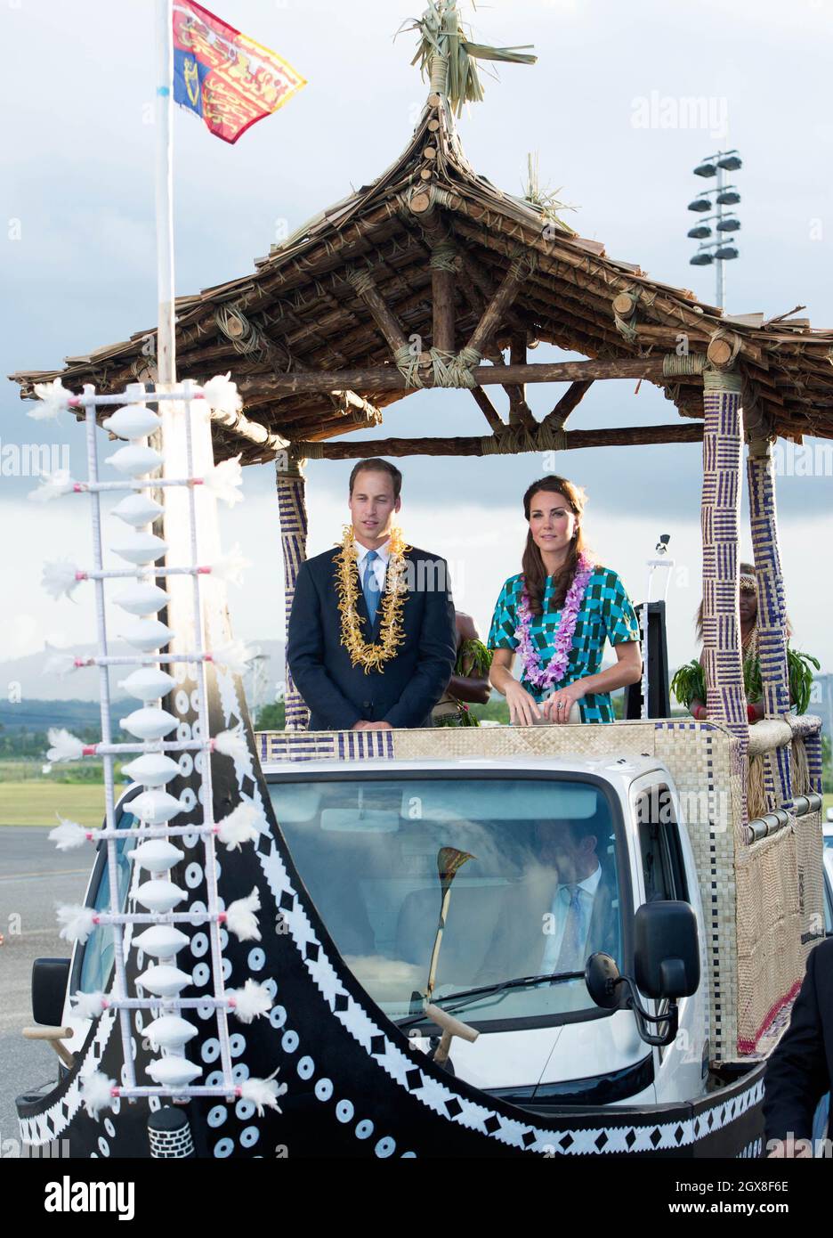Catherine, Duchessa di Cambridge e il Principe William, Duca di Cambridge, indossando le tradizionali ghirlande, viaggiano in un veicolo scoperto a forma di canoa dopo il loro arrivo all'Aeroporto Henderson di Honiara, Isole Salomone, il 16 settembre 2012. Foto Stock