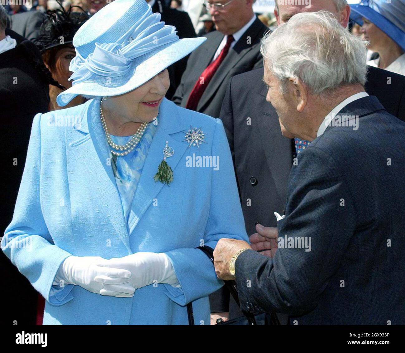 La regina incontra il comico Sir Norman Sapienza, durante la sua visita all'isola di Man. Sir Norman si ruppe con il protocollo reale afferrando il braccio della regina mentre si allontanava da lui. Il comico di 88 anni disse: "Volevo solo dire ancora una volta quanto fosse emozionante vederla". Mezza lunghezza, cappello blu, collana, broccia, guanti bianchi, cappotto blu Foto Stock