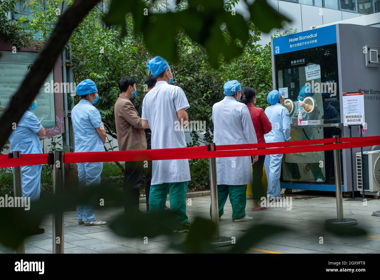 Il personale medico cinese e i residenti ordinari si allineano in un ospedale per il test degli acidi nucleici covid-19 a Pechino, Cina. 05 ottobre 2021 Foto Stock