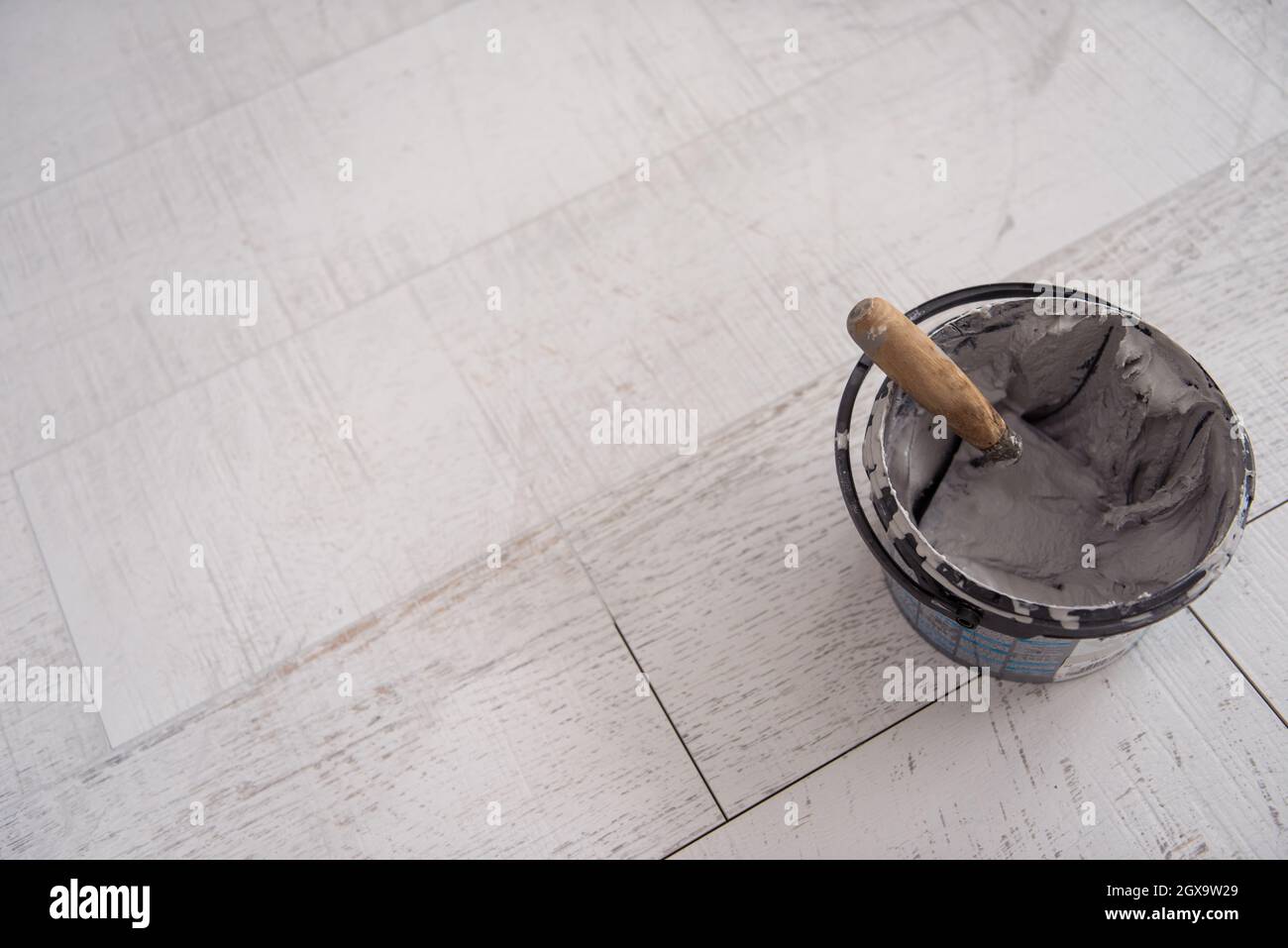 Tiler posa piastrelle adesive al pavimento con la cazzuola intagliata Foto  stock - Alamy