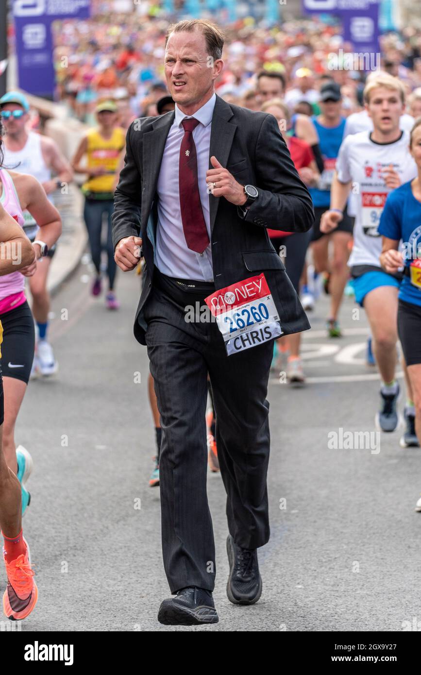 Chris Peskett che corre nella Maratona Virgin Money London 2021, a Tower Hill, Londra, Regno Unito, indossando un abito e una cravatta Foto Stock