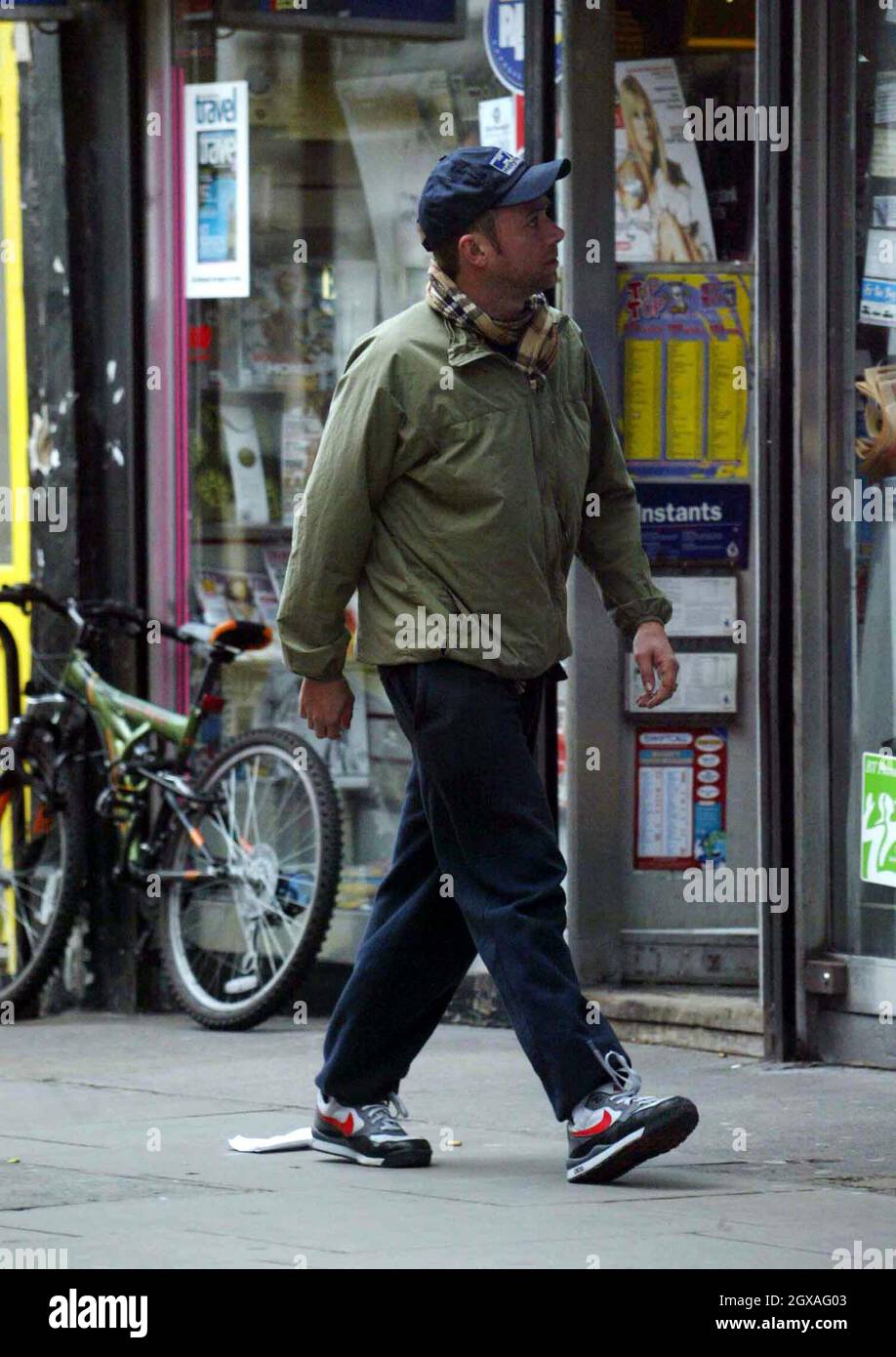 Damon Albarn attira i soldi per dare un'occhiata a un mini scooter. Foto Stock