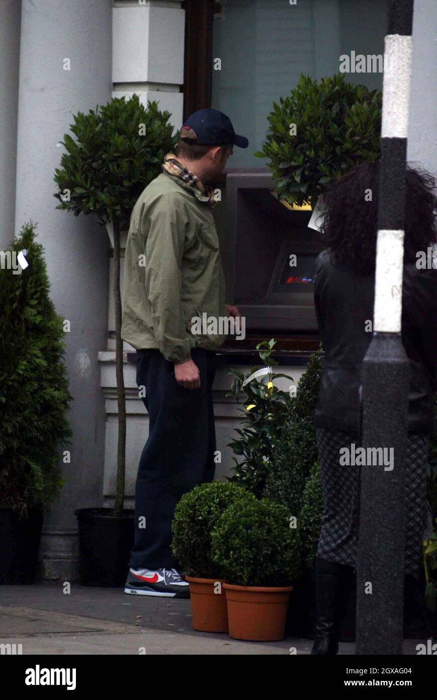 Damon Albarn attira i soldi per dare un'occhiata a un mini scooter. Foto Stock