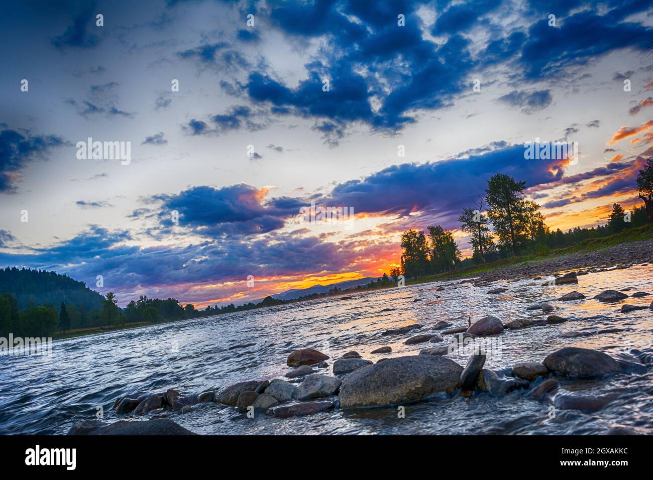 Estate tramonto pietra paesaggio fiume con cielo nuvoloso blu Foto Stock