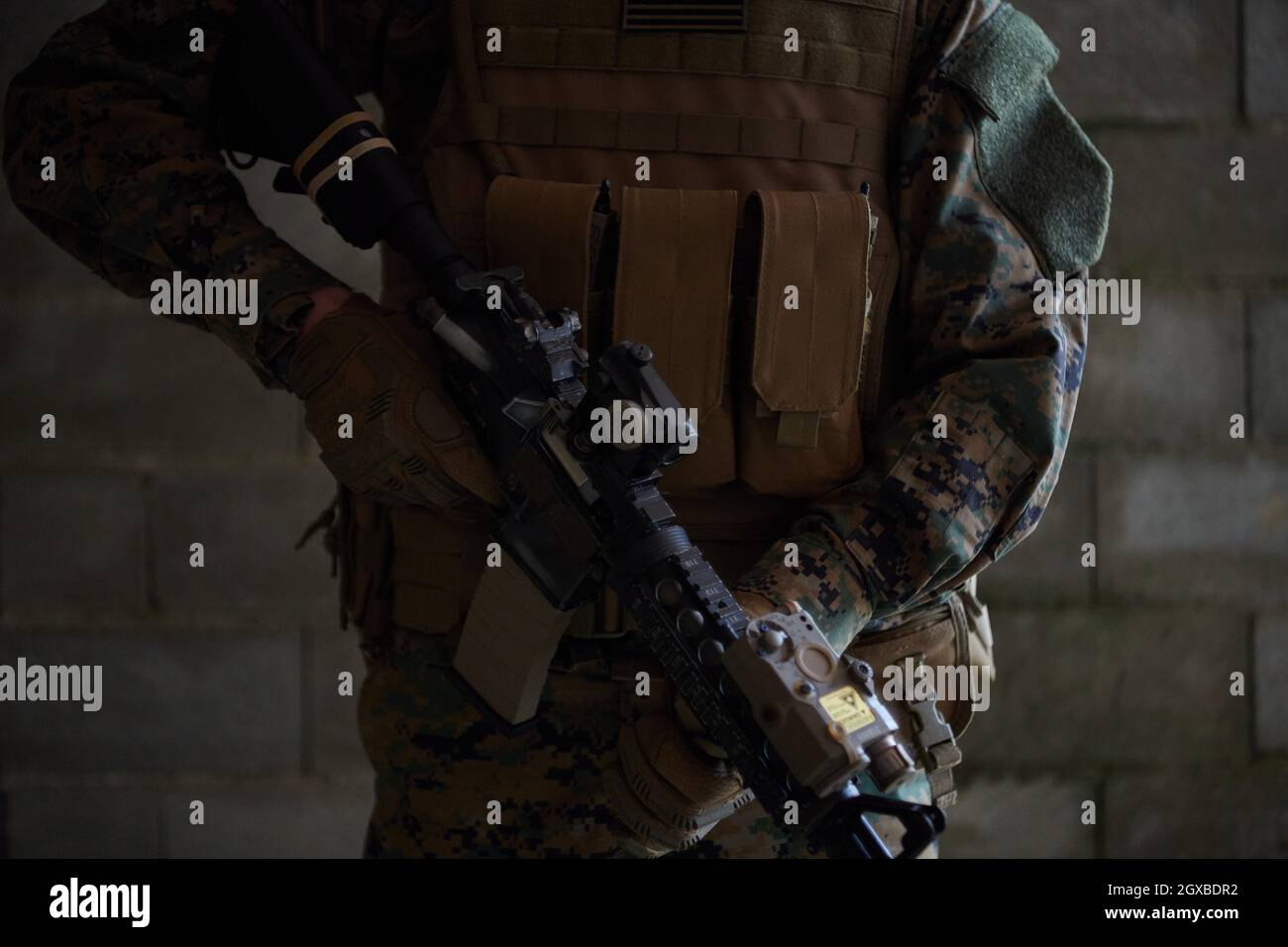 moderno soldato bellico in azione che punta su ottiche a vista laser in posizione di combattimento e alla ricerca di bersaglio in battaglia Foto Stock