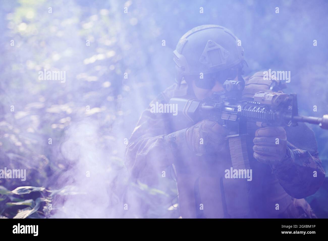 moderno soldato bellico in azione che punta su ottiche a vista laser in posizione di combattimento e alla ricerca di bersaglio in battaglia Foto Stock
