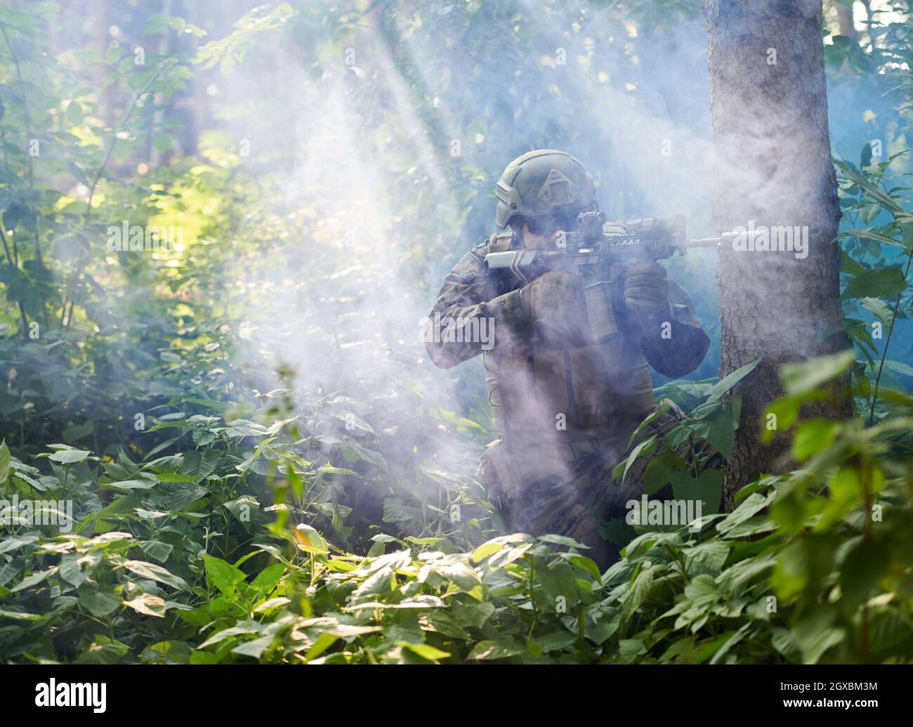 moderno soldato bellico in azione che punta su ottiche a vista laser in posizione di combattimento e alla ricerca di bersaglio in battaglia Foto Stock