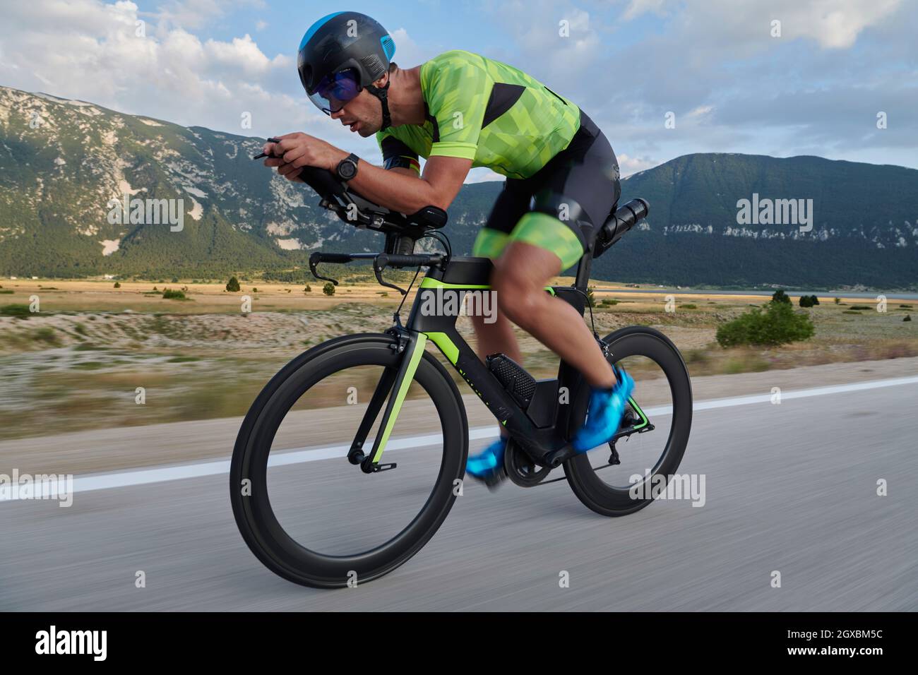 l'atleta di triathlon guida una bicicletta da corsa professionale durante l' allenamento su una strada di campagna curvilinea Foto stock - Alamy