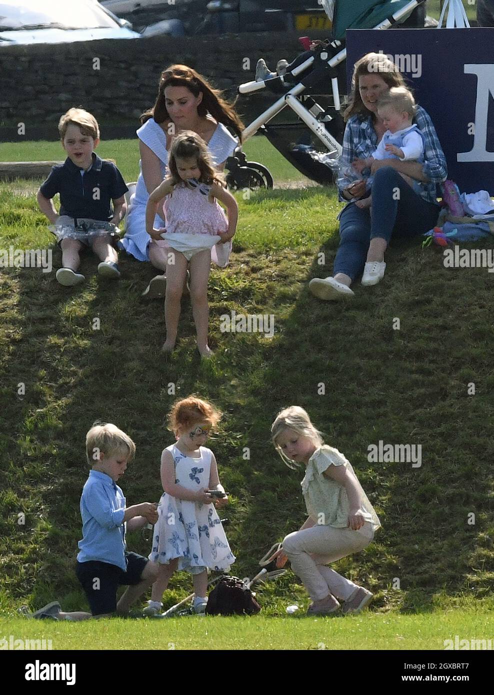 Catherine, Duchessa di Cambridge si rilassa su una banca d'erba con la Principessa Charlotte di Cambridge, il Principe Giorgio di Cambridge e gli amici durante la Maserati Royal Charity Polo al Beaufort Polo Club vicino a Tetbury il 10 giugno 20)8. Foto Stock