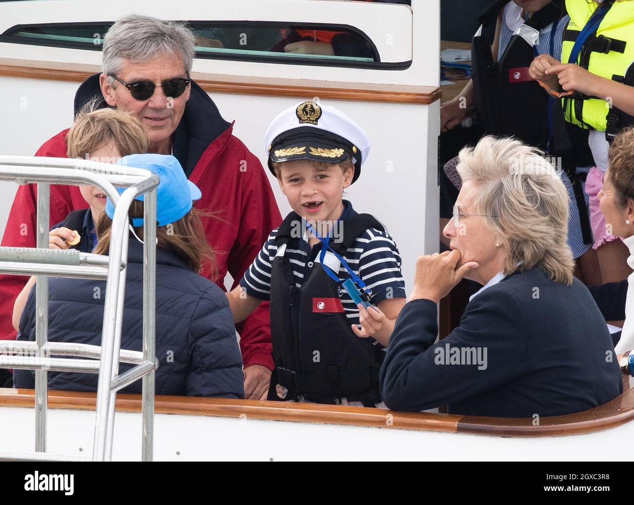 Il principe George, con i denti anteriori mancanti e la testa del capitano, e Michael Middleton guardano la regata inaugurale della King's Cup, ospitata dal duca e dalla duchessa di Cambridge, a Cowes, Isola di Wight l'8 agosto 2019. Foto Stock