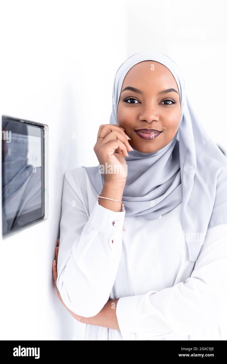 Giovane africana moderna donna musulmana utilizzando smart nella schermata iniziale del sistema di controllo Foto Stock