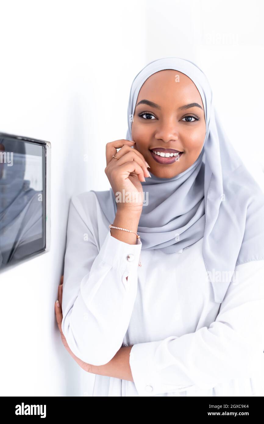 Giovane africana moderna donna musulmana utilizzando smart nella schermata iniziale del sistema di controllo Foto Stock