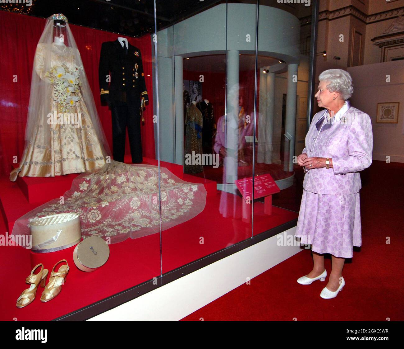 La regina Elisabetta II guarda la sua abito da sposa 1947 e il sentiero  nuziale 13 piedi progettato da Norman Hartnell con l'uniforme navale  indossata dal Duca di Edimburgo, che sono in