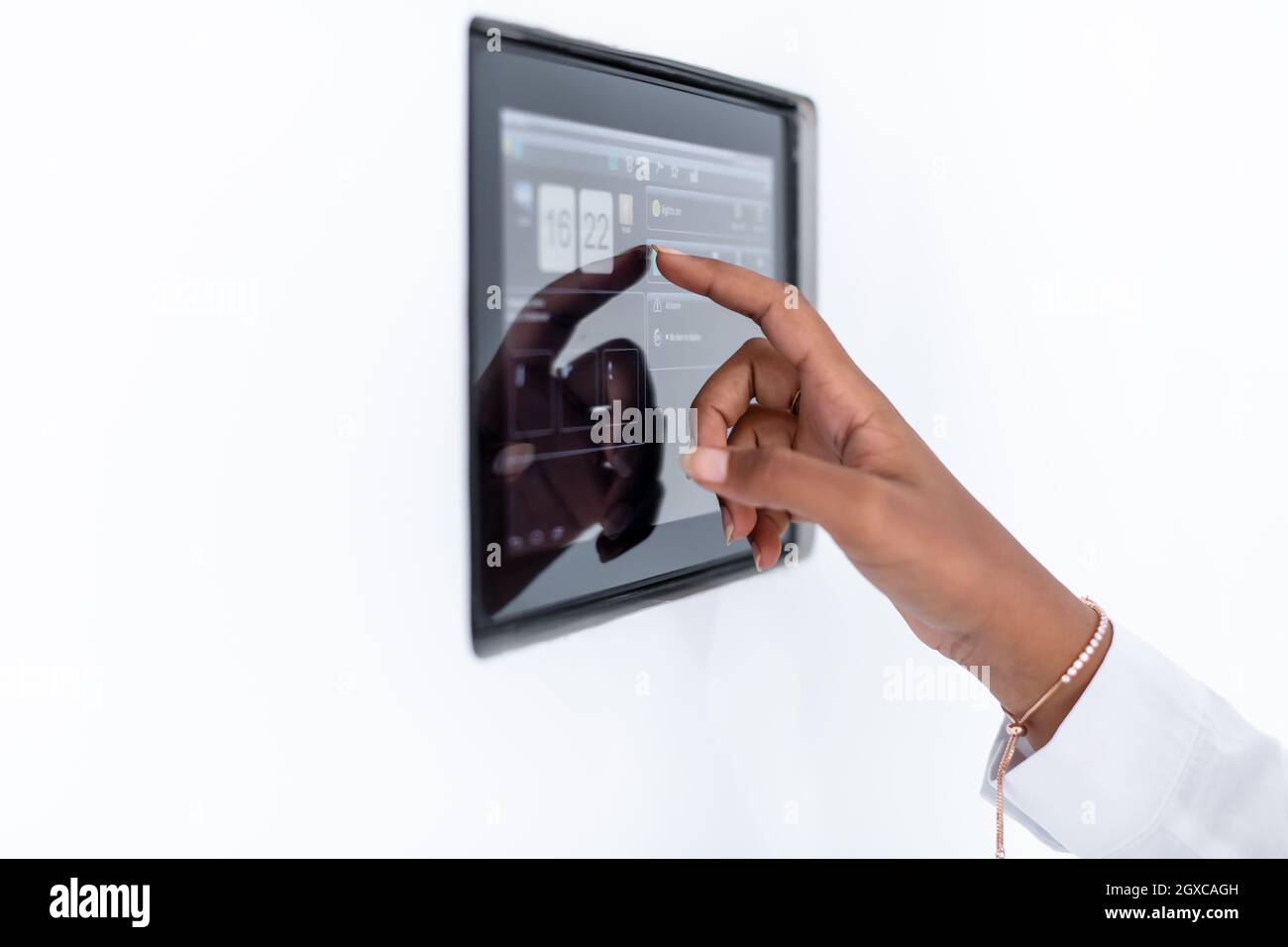 Giovane africana moderna donna musulmana utilizzando smart nella schermata iniziale del sistema di controllo Foto Stock