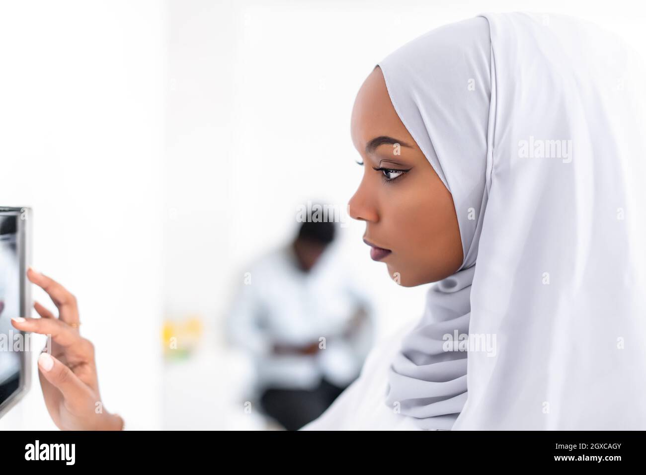 Giovane africana moderna donna musulmana utilizzando smart nella schermata iniziale del sistema di controllo Foto Stock