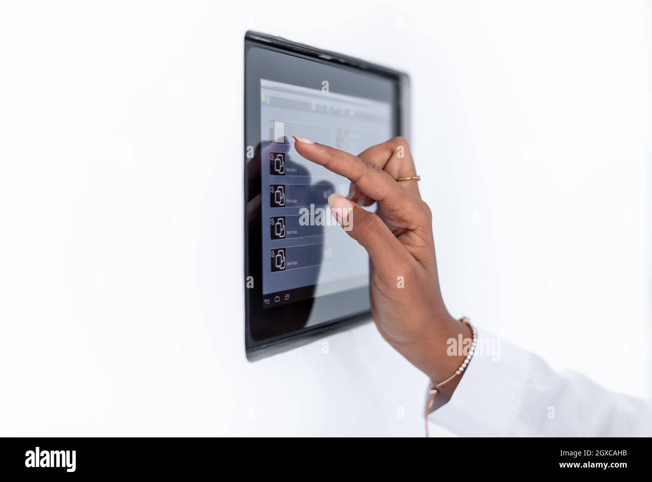 Giovane africana moderna donna musulmana utilizzando smart nella schermata iniziale del sistema di controllo Foto Stock