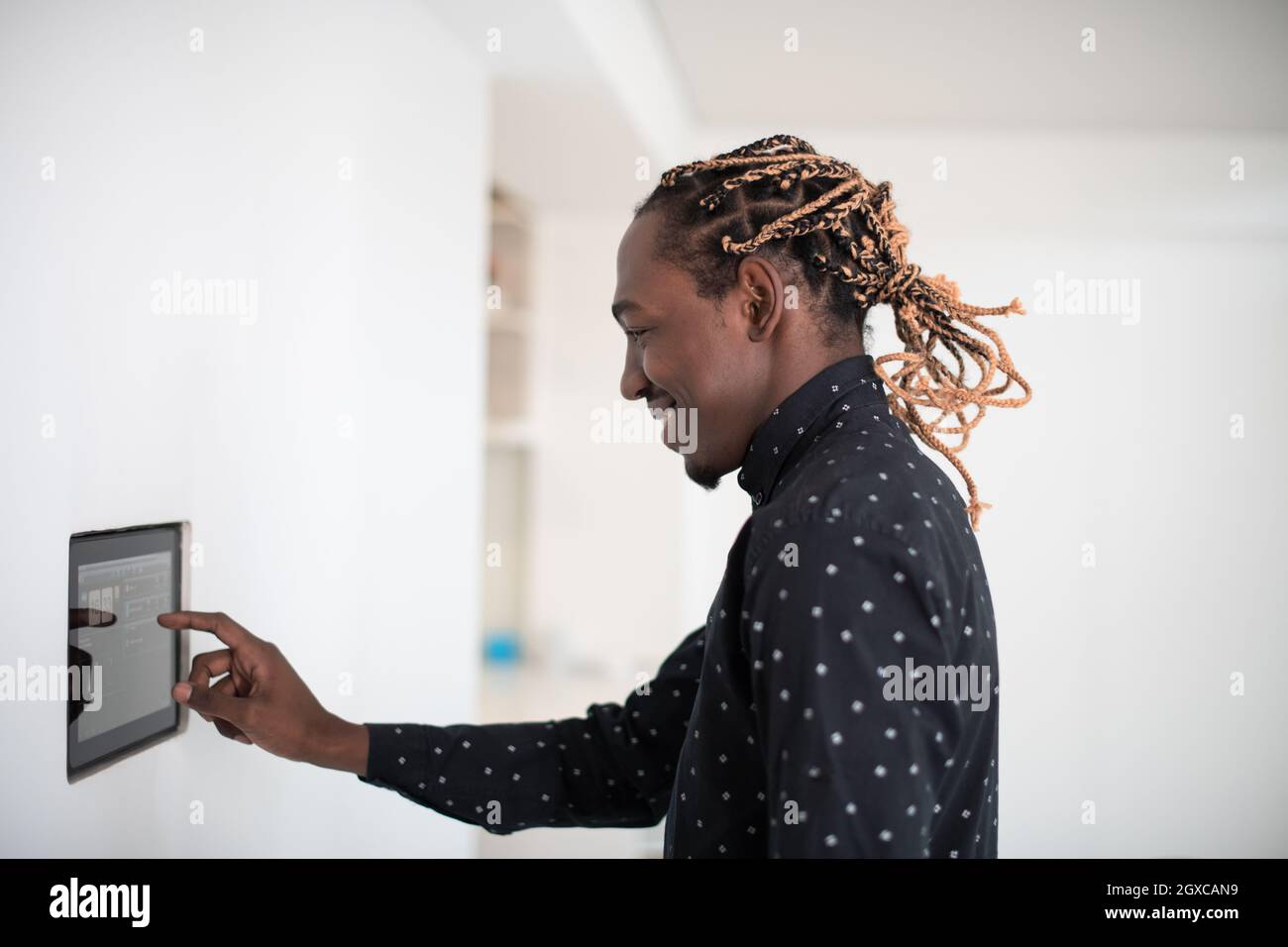 L'uomo africano utilizzando smart nella schermata iniziale del sistema di controllo Foto Stock