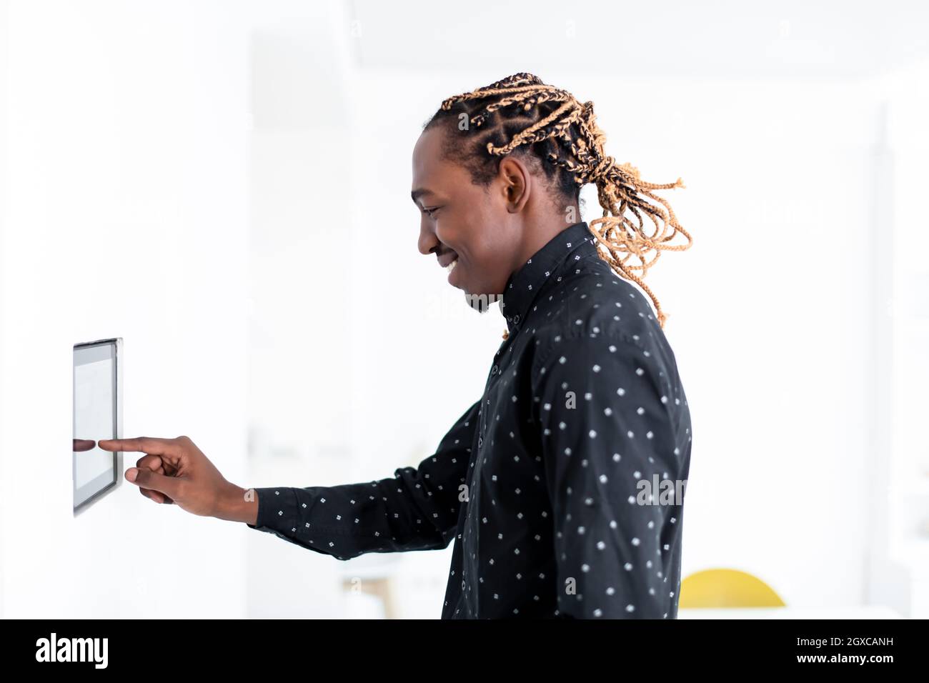 L'uomo africano utilizzando smart nella schermata iniziale del sistema di controllo Foto Stock