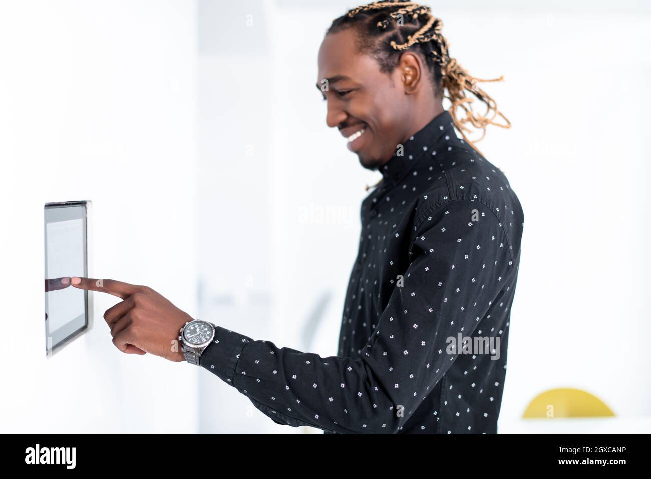 L'uomo africano utilizzando smart nella schermata iniziale del sistema di controllo Foto Stock