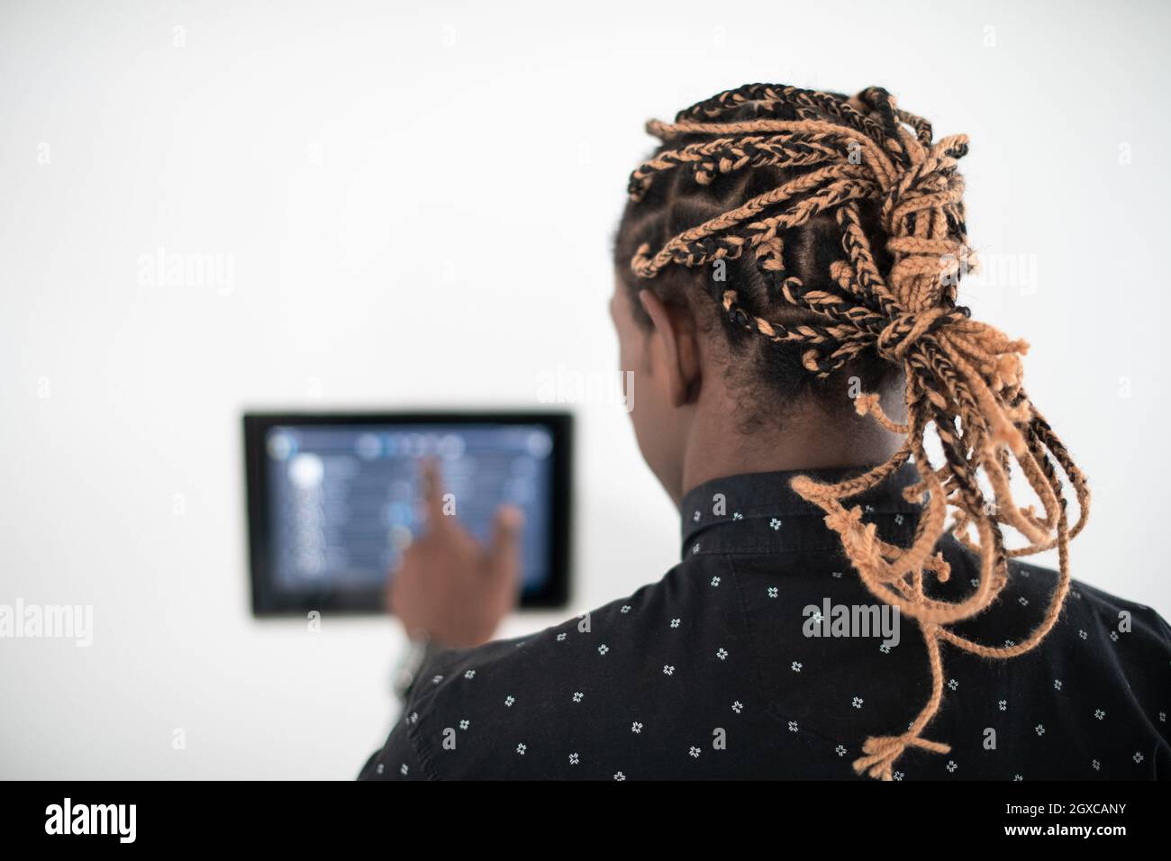 L'uomo africano utilizzando smart nella schermata iniziale del sistema di controllo Foto Stock