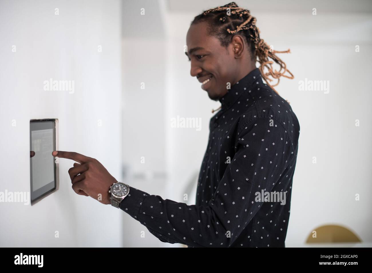L'uomo africano utilizzando smart nella schermata iniziale del sistema di controllo Foto Stock