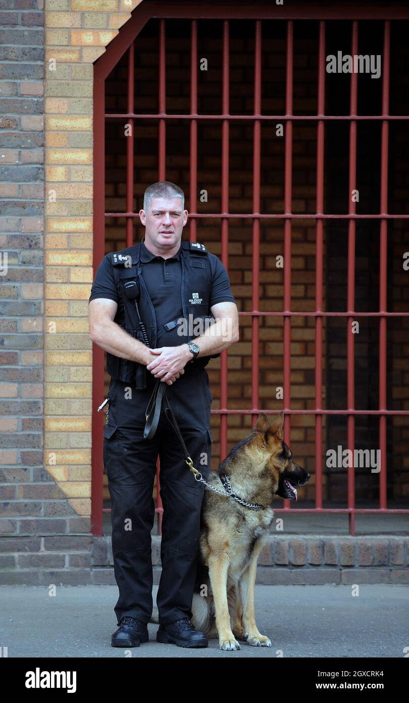 Una guardia carceraria e un cane di guardia sono visti fuori Belmarsh (prigione HM) nel sud-est di Londra Foto Stock