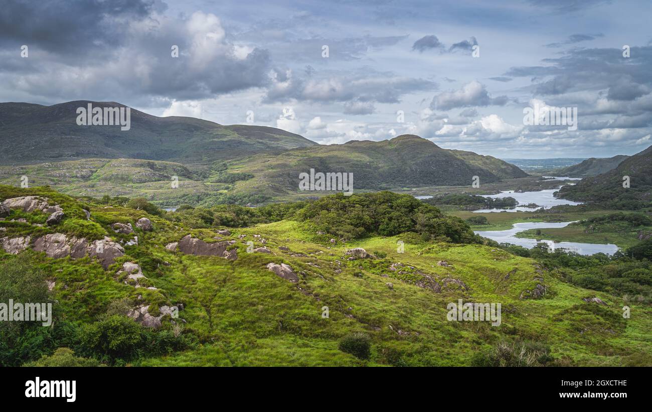 Iconico punto panoramico irlandese, Ladies View e Lakes of Killarney. Valle e montagne rocciose con cielo drammatico, Rink di Kerry, Irlanda Foto Stock