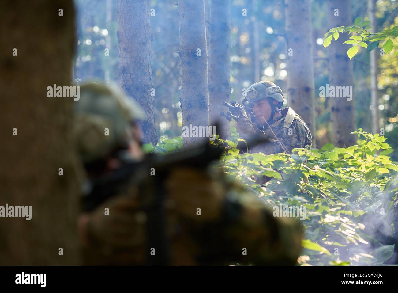 moderno soldato bellico in azione che punta su ottiche a vista laser in posizione di combattimento e alla ricerca di bersaglio in battaglia Foto Stock