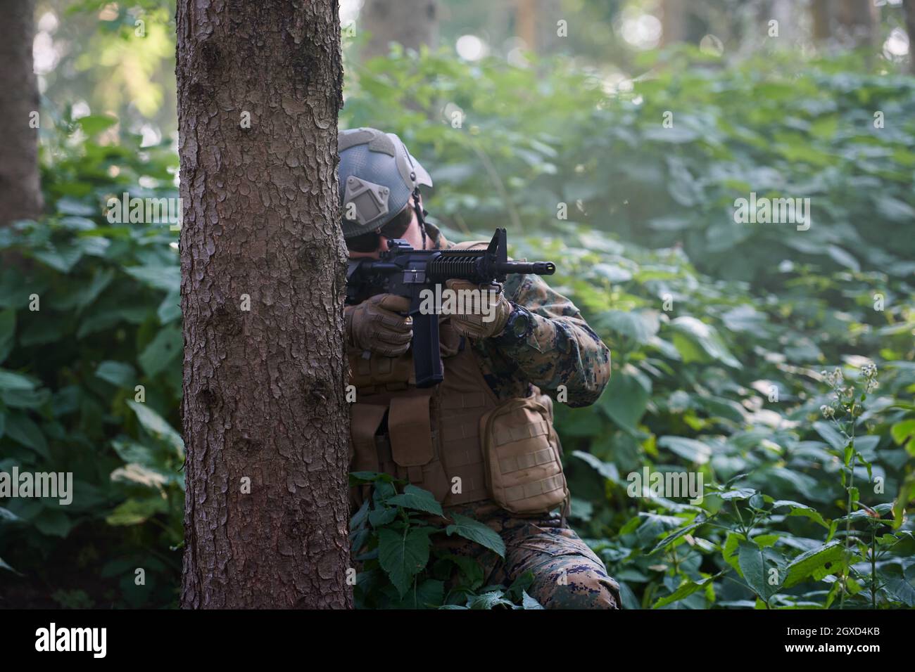 moderno soldato bellico in azione che punta su ottiche a vista laser in posizione di combattimento e alla ricerca di bersaglio in battaglia Foto Stock
