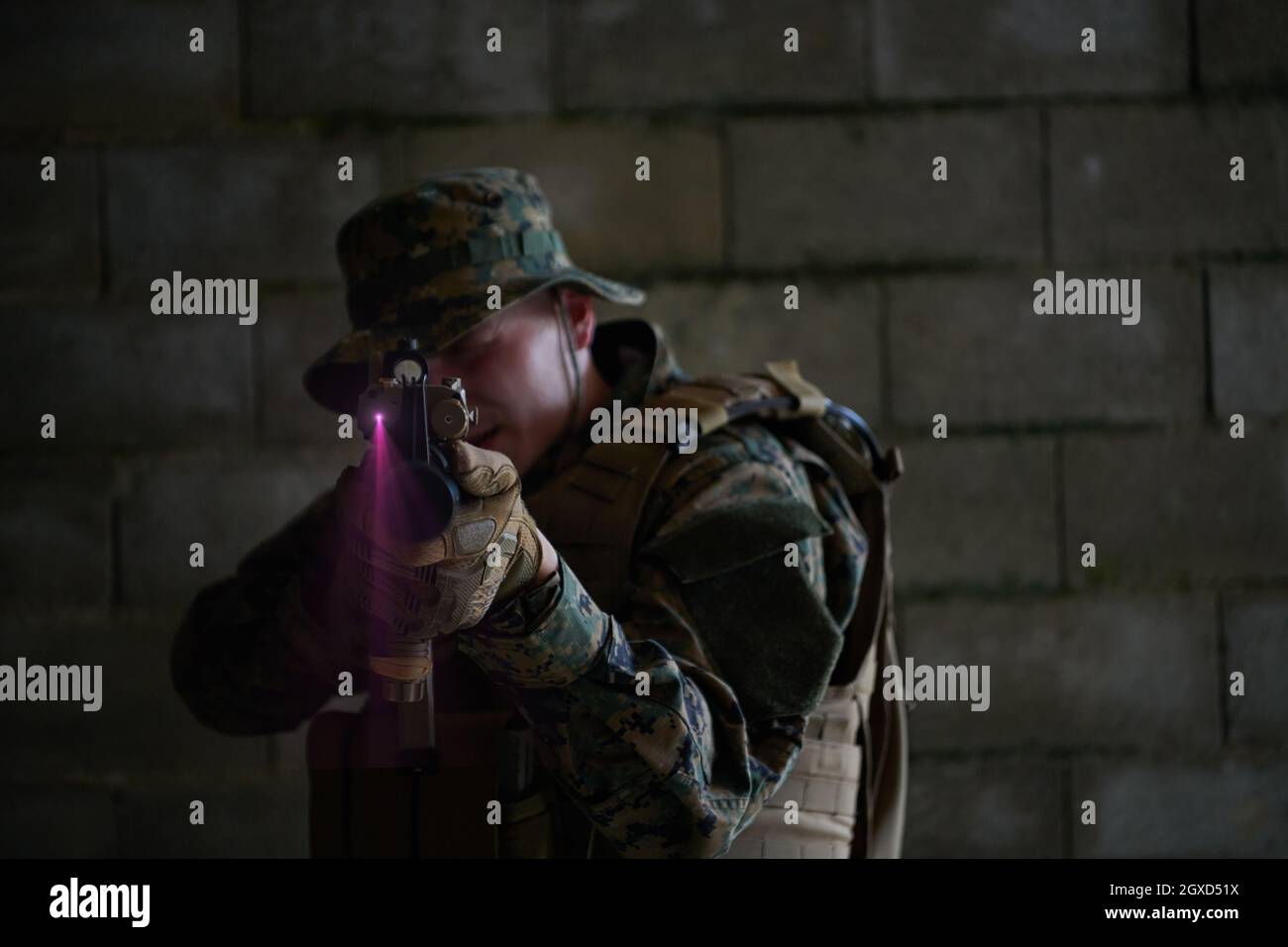 moderno soldato bellico in azione che punta su ottiche a vista laser in posizione di combattimento e alla ricerca di bersaglio in battaglia Foto Stock