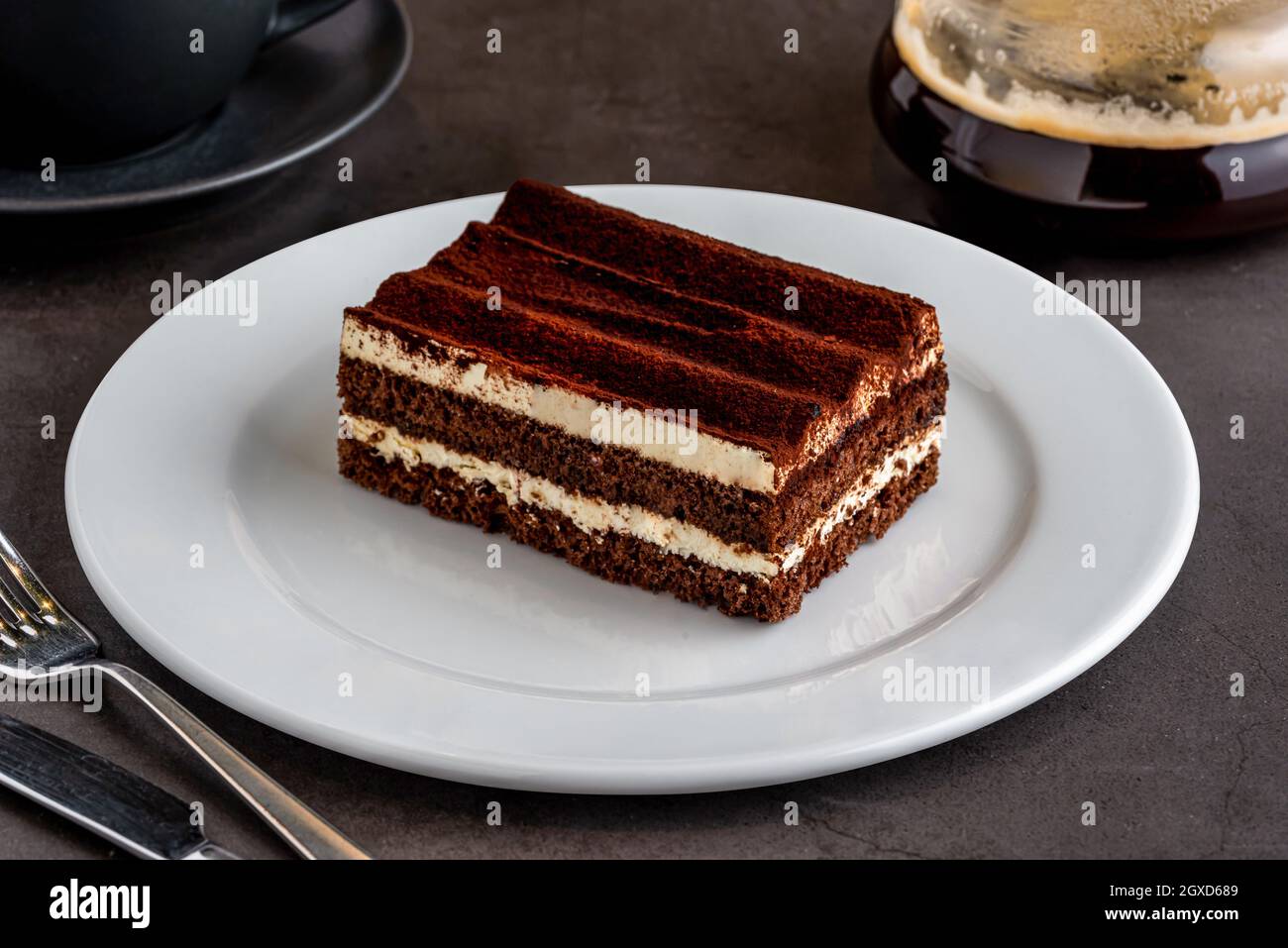 Gourmet di dessert italiano tiramisù con caffè preparato su tavola di pietra nera Foto Stock