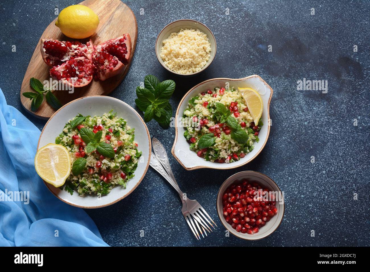 Insalata sana con couscous, menta fresca, cetriolo, melograno, limone e olio d'oliva. Cucina orientale. Concetto di cibo vegano. Cibo tradizionale israeliano Foto Stock