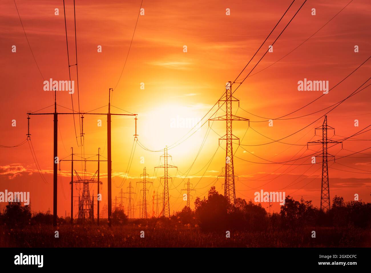 Crisi energetica: Linee elettriche sullo sfondo del tramonto in toni rossi inquietanti Foto Stock