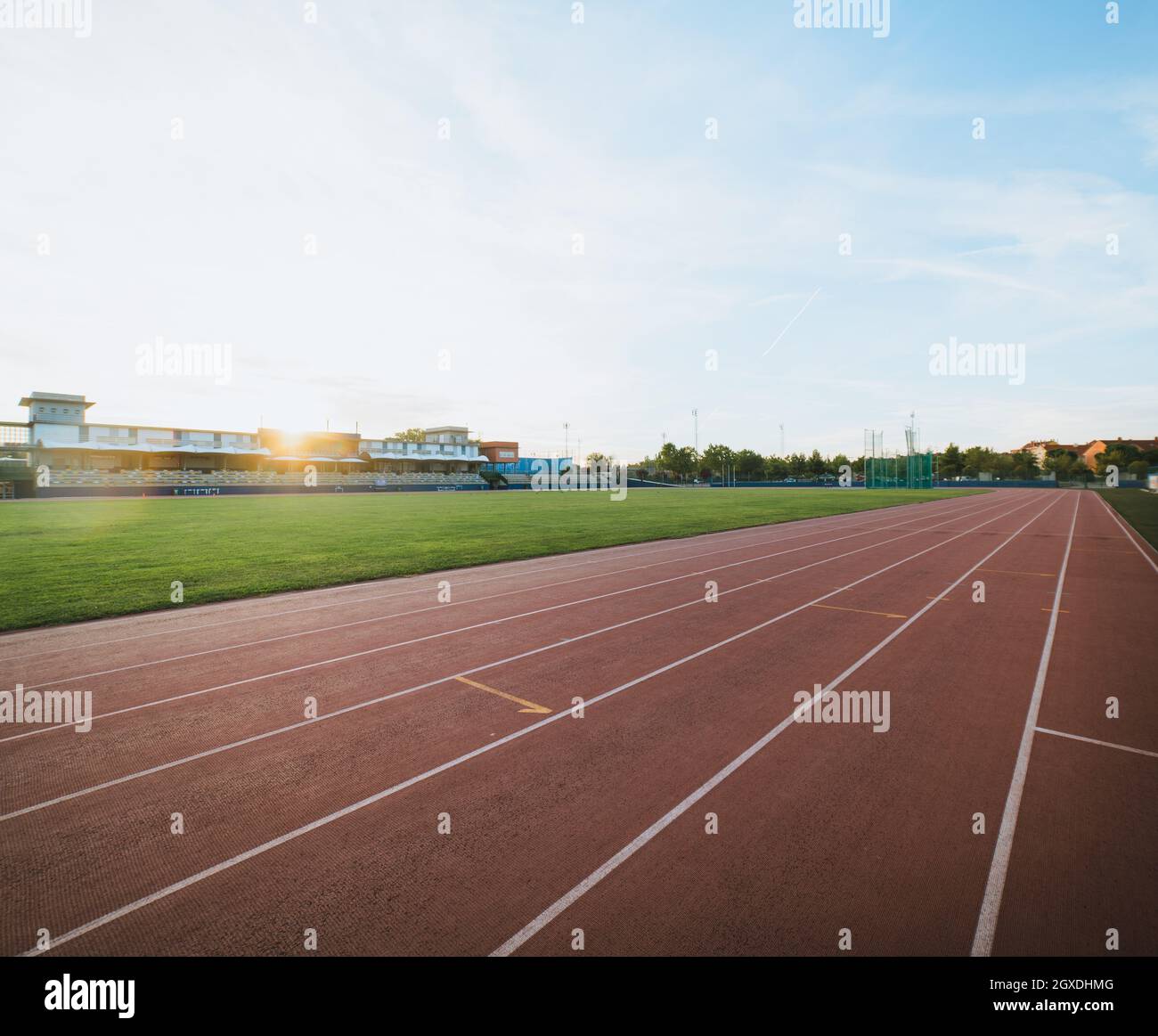 Vista panoramica di piste e campi sportivi contro tribune sotto il cielo lucente nella città di sera Foto Stock