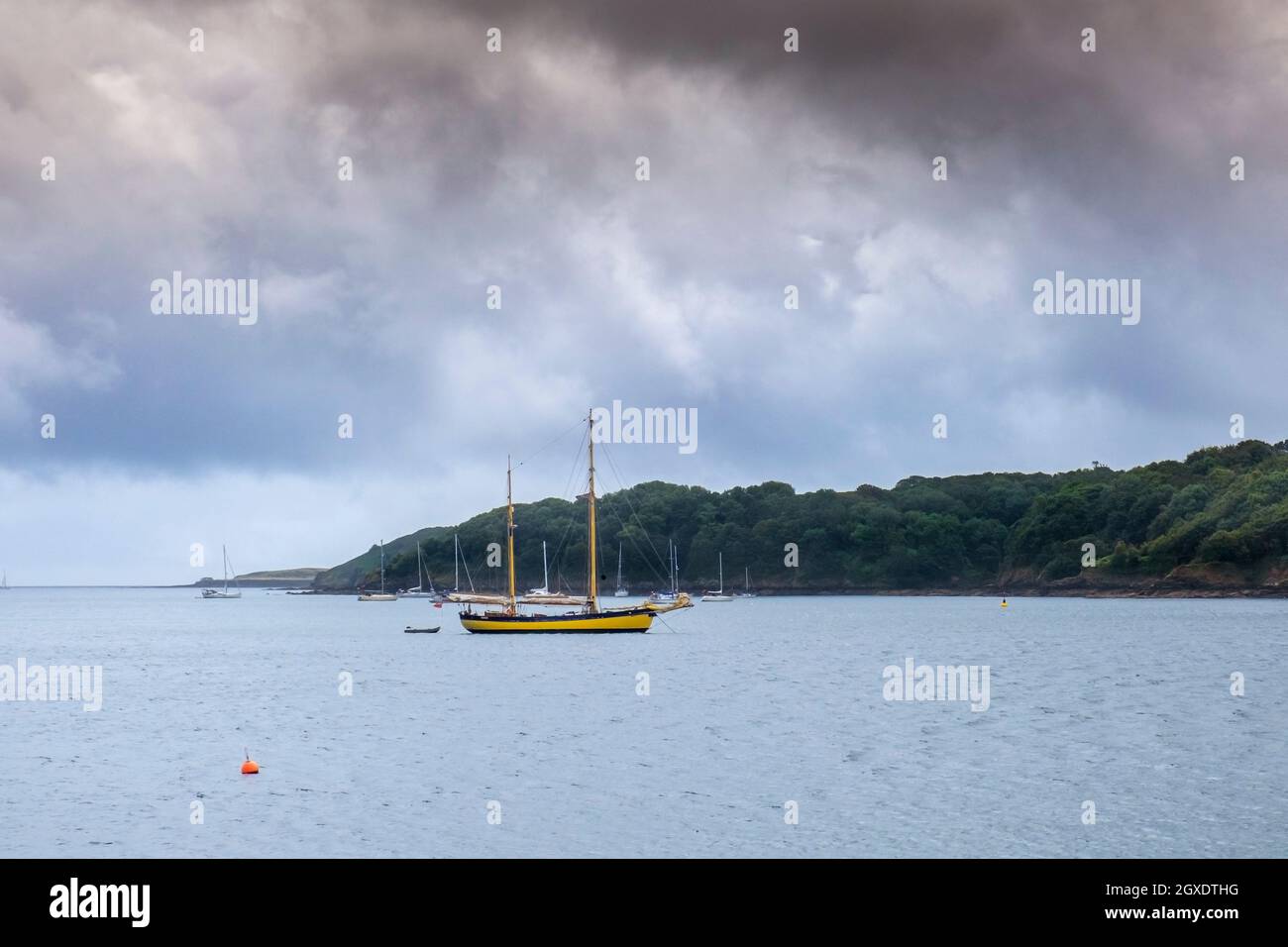 Il tempo nuvoloso cupo sopra le barche a vela ormeggiate nel passaggio del fiume Helford in Cornovaglia. Foto Stock