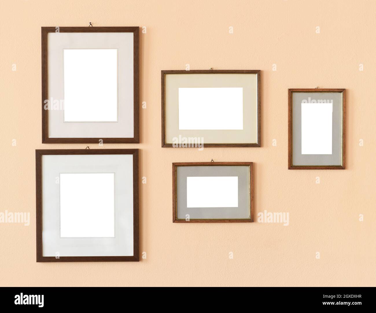 Set di varie cornici rettangolari mockup vuote di diverse dimensioni appese su pareti beige Foto Stock