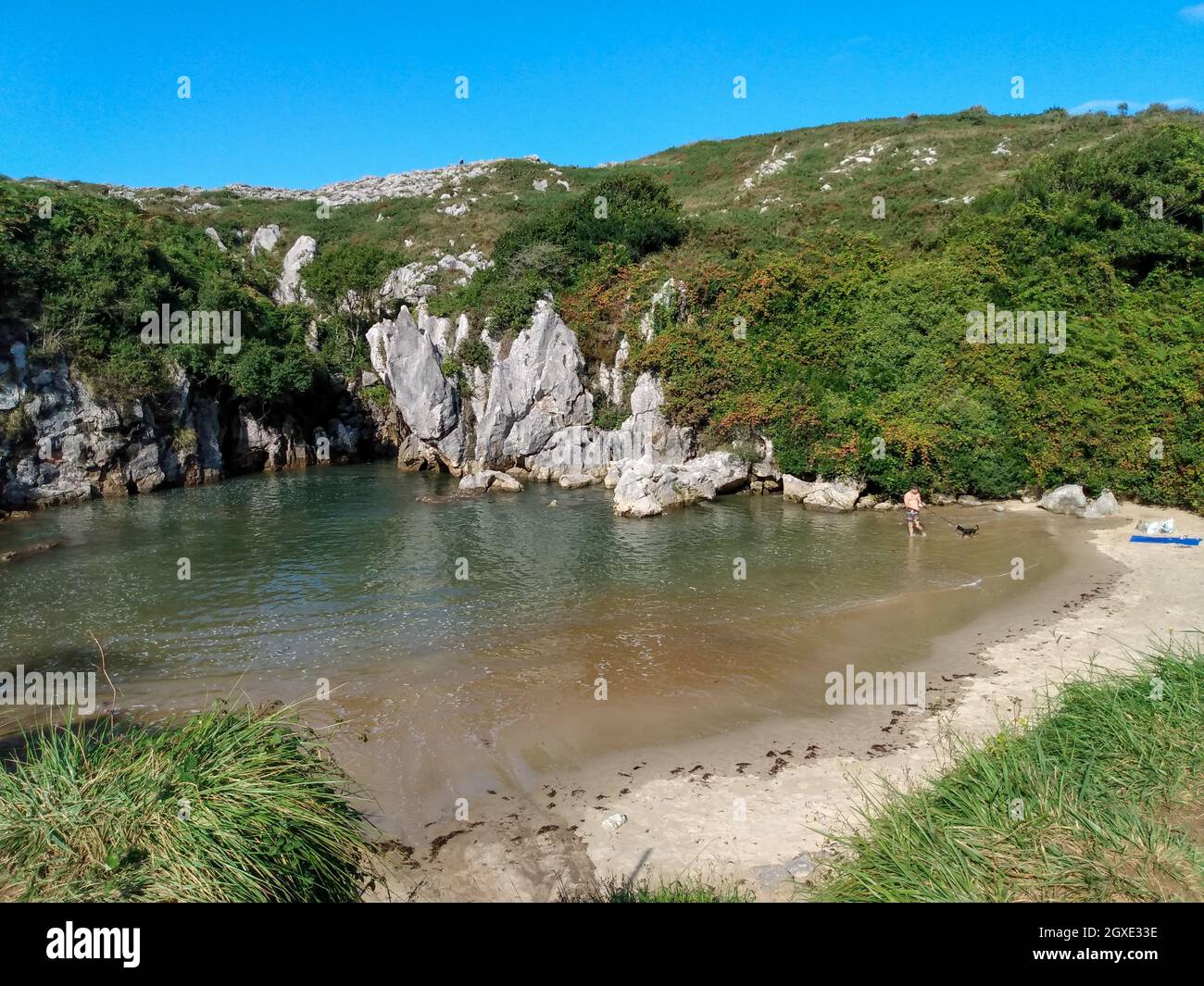 Asturias in Spagna: Playa de Gulpiyuri - una spiaggia nel mezzo di un campo e 300 piedi dall'oceano. Foto Stock
