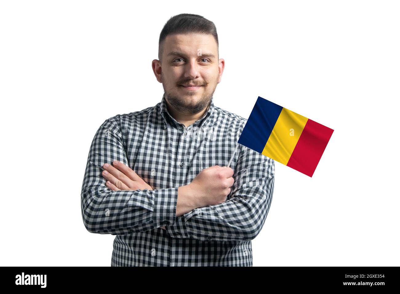 Ragazzo bianco che tiene una bandiera del Ciad sorridente fiducioso con le armi incrociate isolate su uno sfondo bianco. Foto Stock