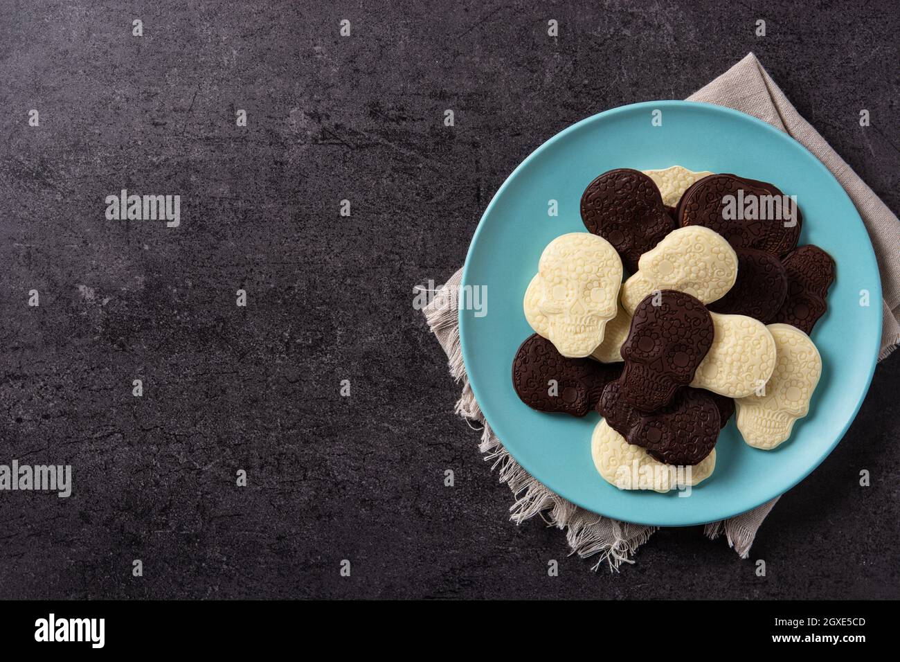 Teschi messicani al cioccolato in piatto su sfondo di pietra nera Foto Stock