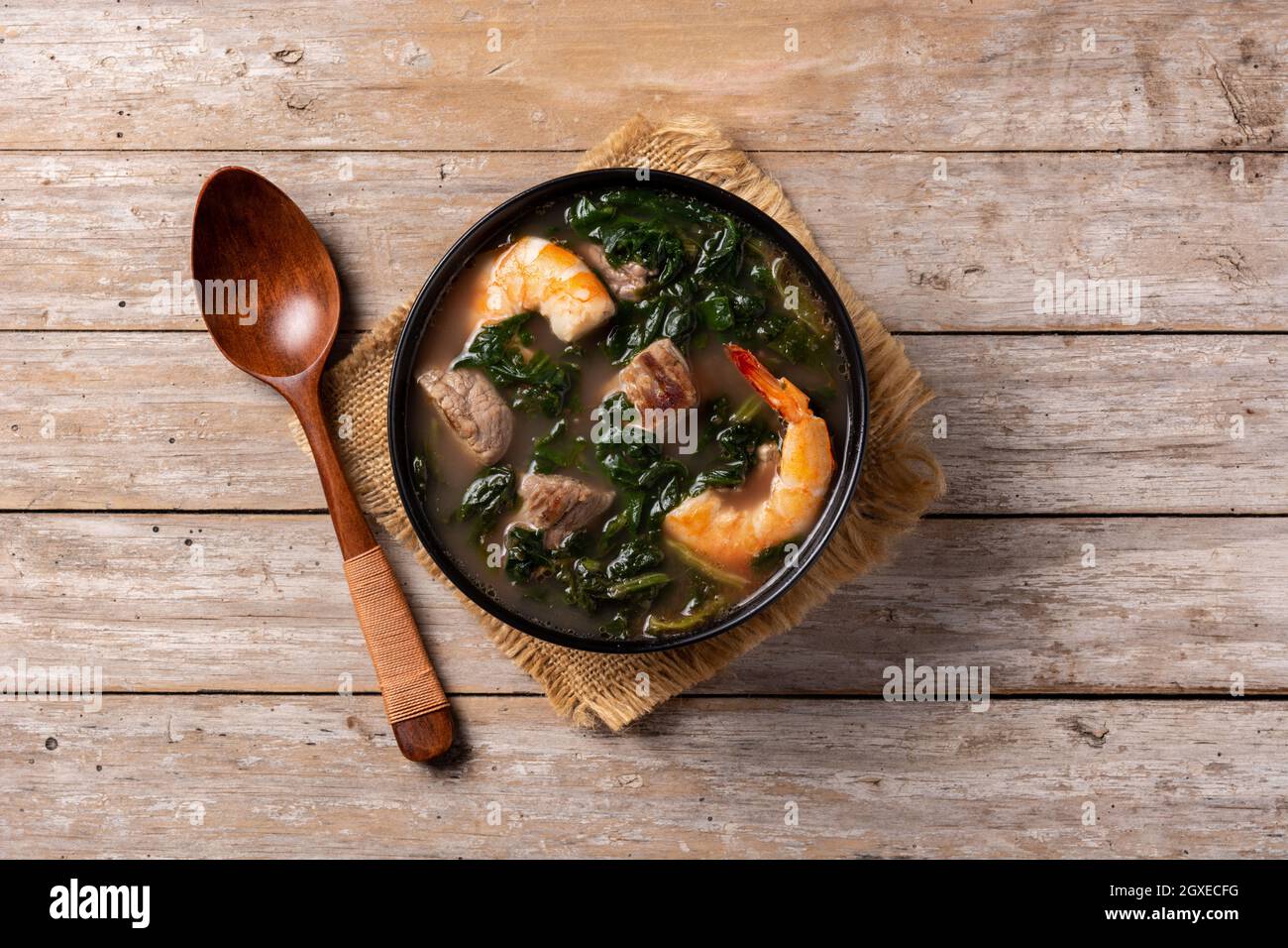 Zuppa di manzo, stufato di okra e spinaci in ciotola su tavola di legno Foto Stock