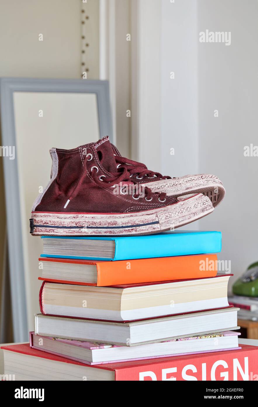 Vecchie scarpe di tela su libri impilano Foto Stock