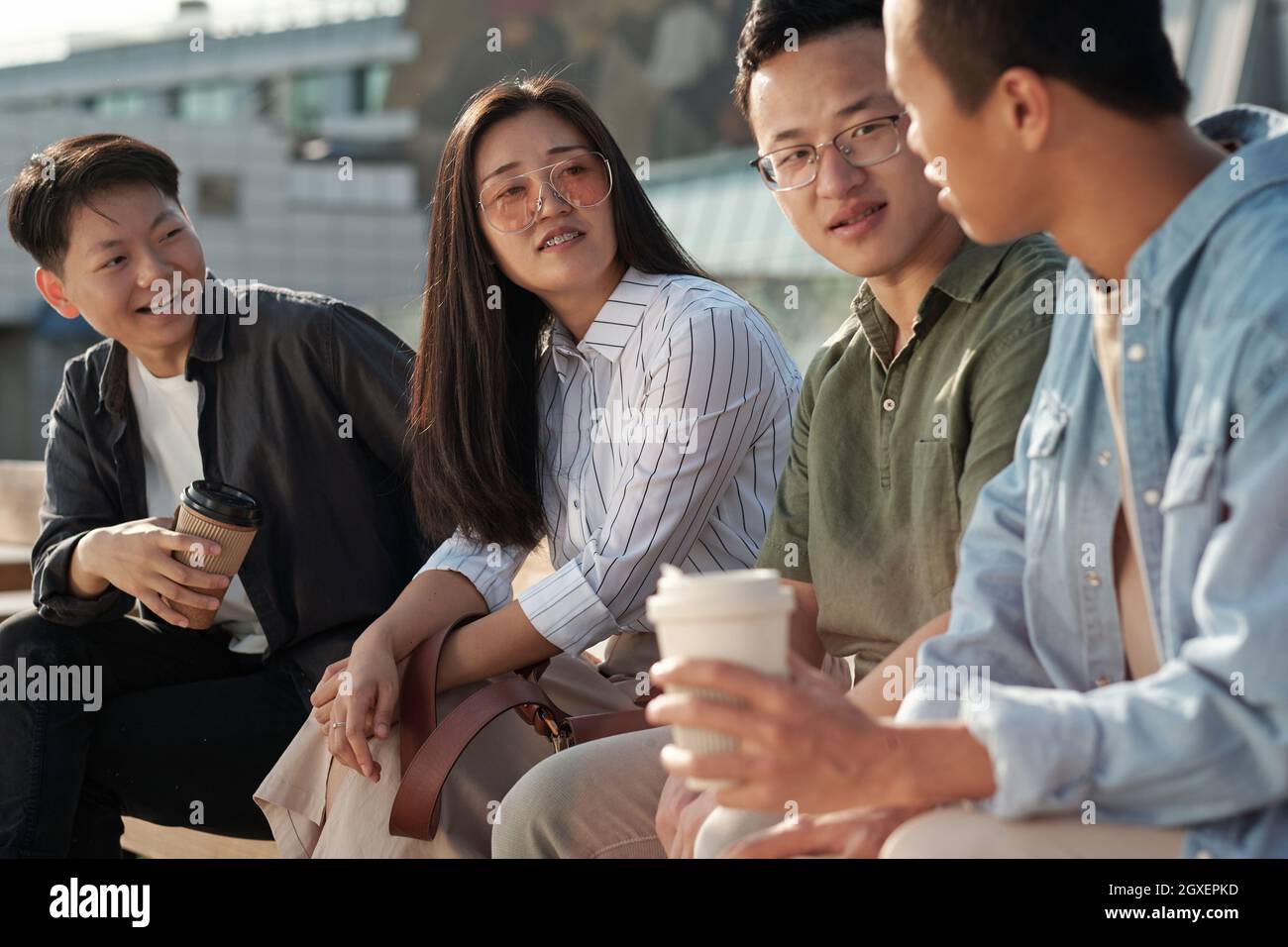 Gruppo di colleghi che discutono dei punti di lavoro durante una riunione all'aperto Foto Stock
