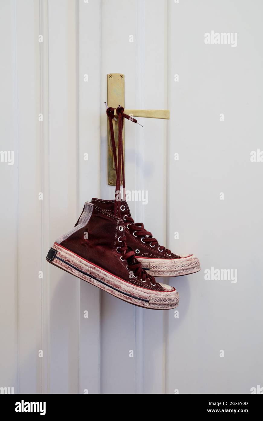 Sneakers appesi sulla porta Foto Stock