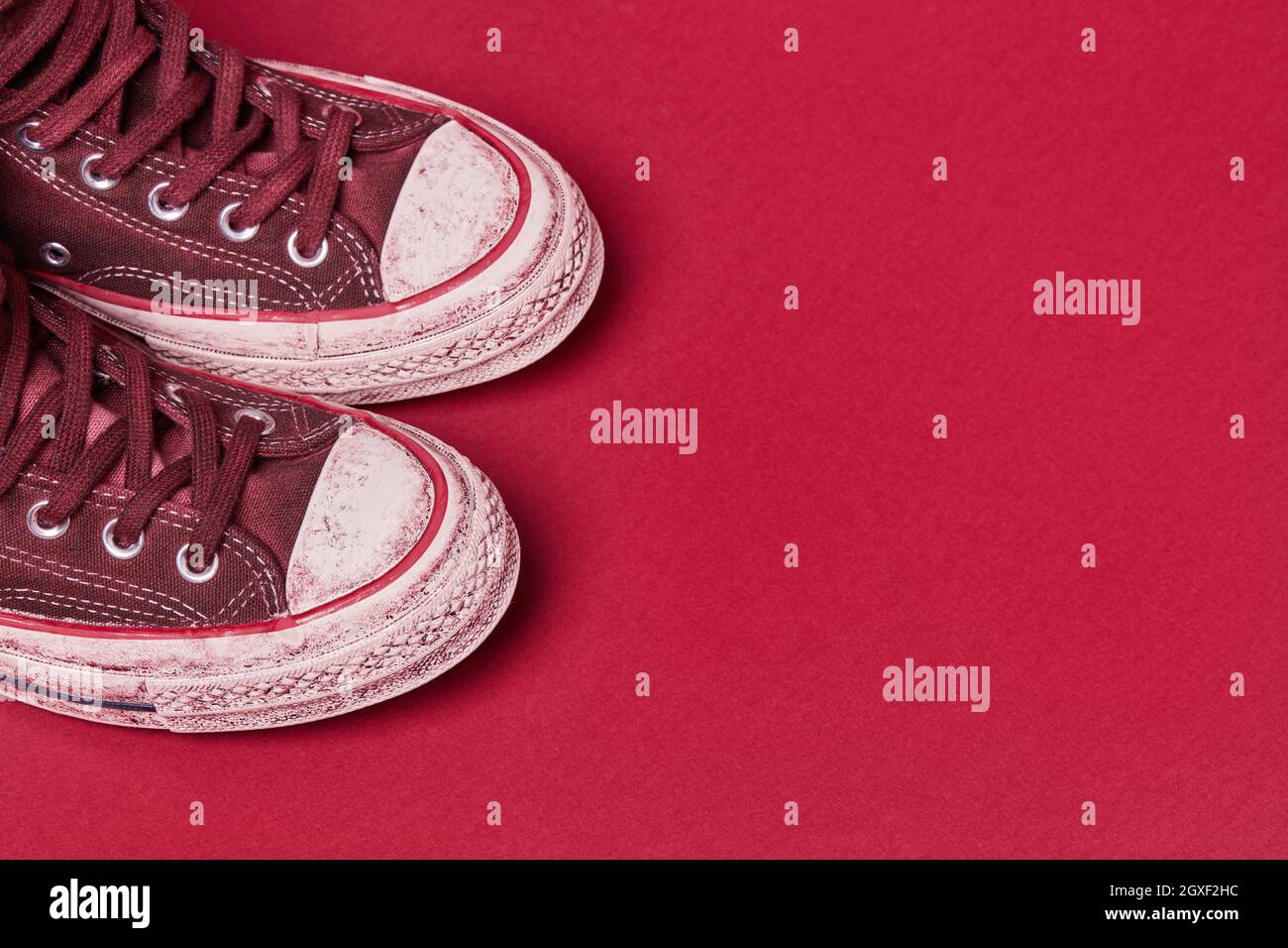 Scarpe di tela usate su sfondo rosso Foto Stock