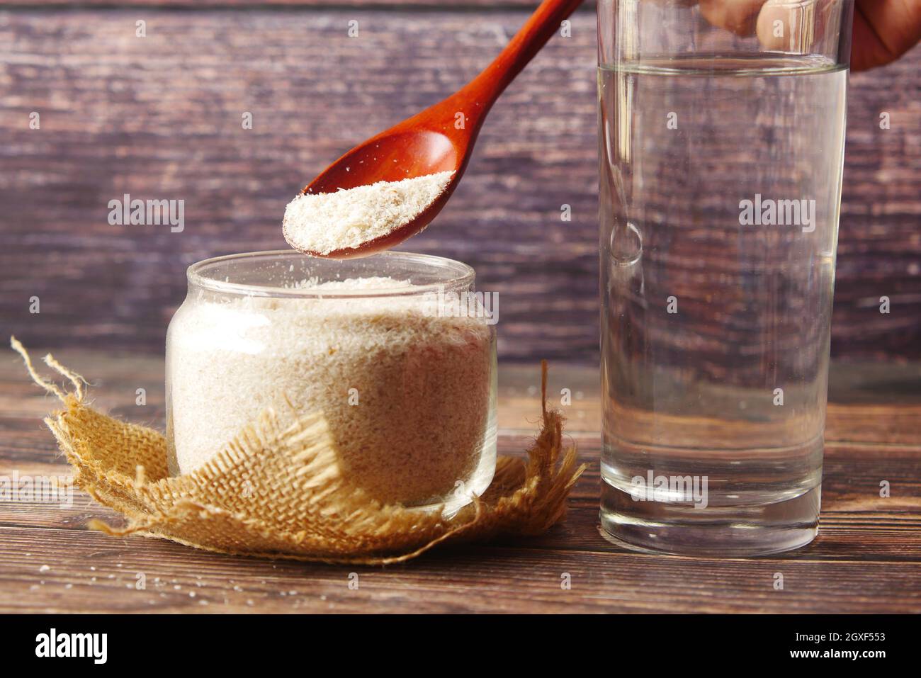Il cucchiaio di legno con semi di psillio su sfondo scuro Foto Stock