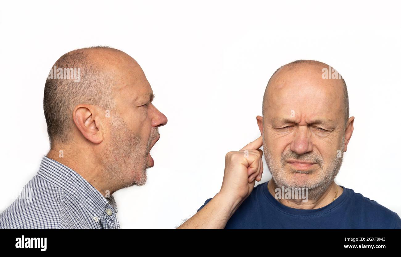 un uomo che urla nell'orecchio. Concetto del suo ego urlando dentro di sé Foto Stock