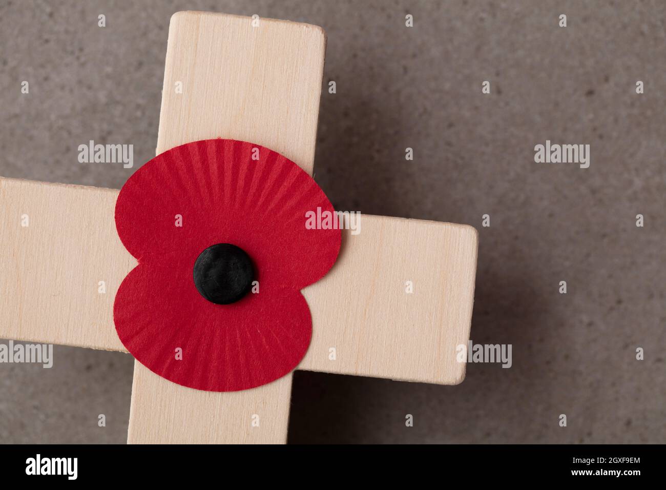 Un papavero rosso ricordo su una croce di legno. Concetto di giornata di ricordo militare Foto Stock