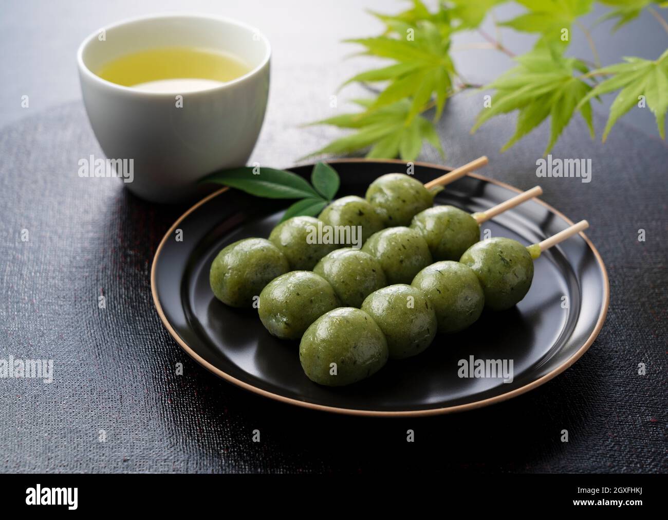 Gnocchi Kusadango e tè verde su sfondo nero. Gnocchi giapponesi Foto Stock