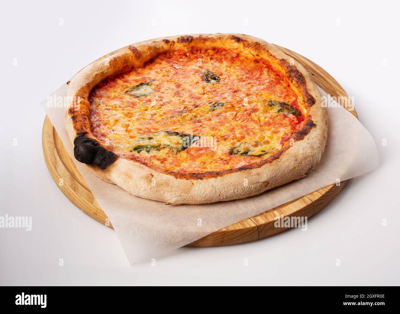 Vista dall'alto della pizza calda su un piedistallo in legno. Pizza Margarita . Base di pomodoro e molta mozzarella, il sapore del formaggio olandese e del basilico fresco. Foto Stock